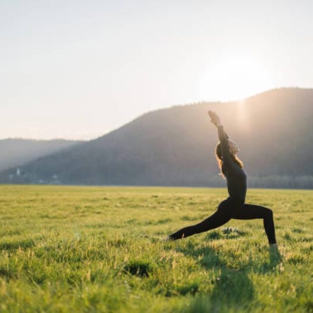 She brings one leg forward into warrior one position, her hands over her head